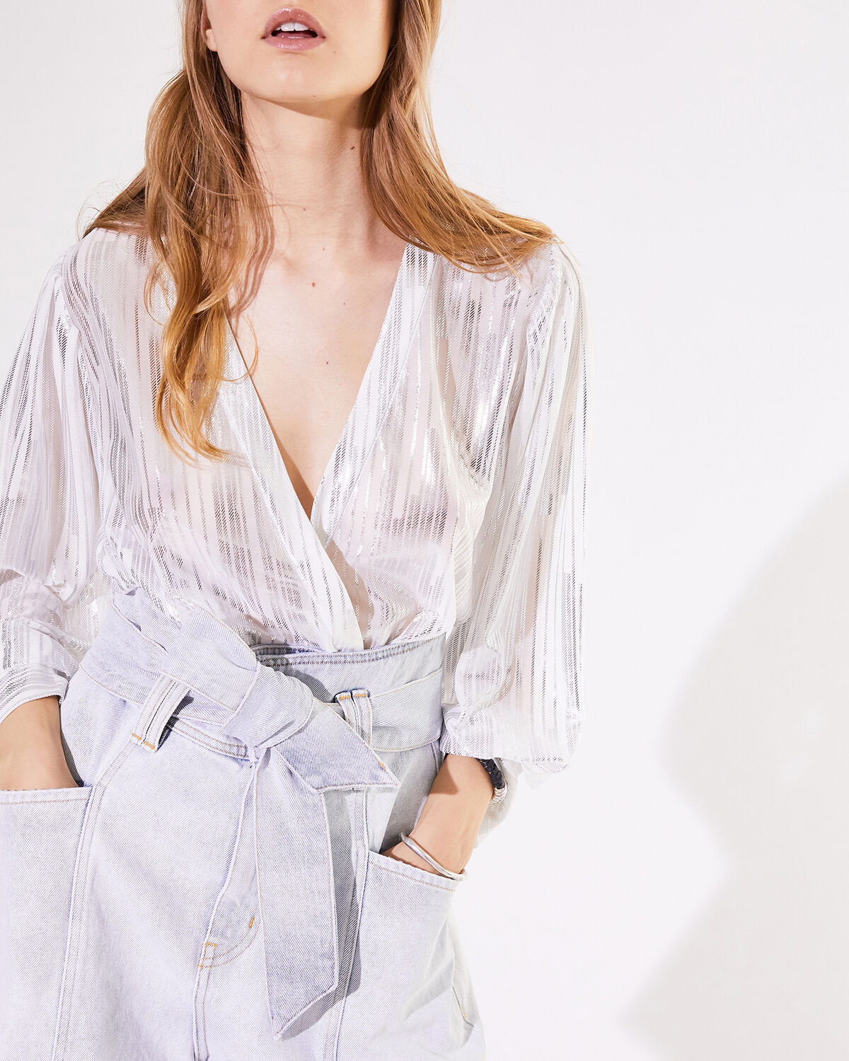 Photo of IRO Paris Darla Top Ecru And Silver - Lightweight And Fluid, This Transparent Top Features Fine Silver Lurex Stripes And A Wrapover Neckline. With Its Tightenable Waist, This Aerial Piece Can Be Worn On All Occasions. Fall Winter 19