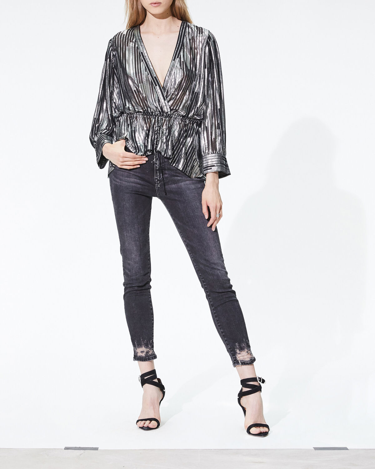 Photo of IRO Paris Darla Top Black And Silver - Lightweight And Fluid, This Transparent Top Features Fine Silver Lurex Stripes And A Wrapover Neckline. With Its Tightenable Waist, This Aerial Piece Can Be Worn On All Occasions. Fall Winter 19